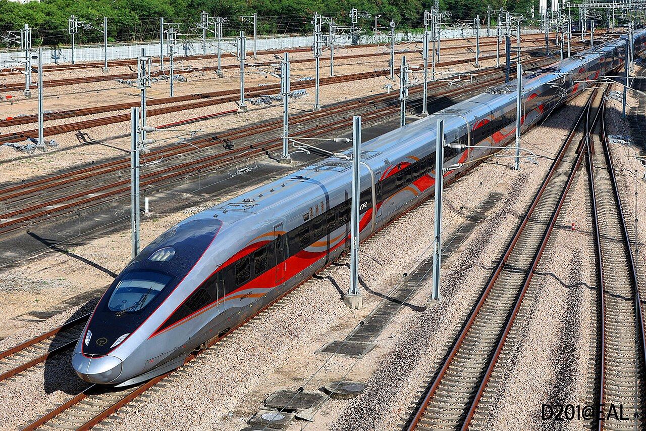 A silver-and-red Fuxing high-speed train on the tracks